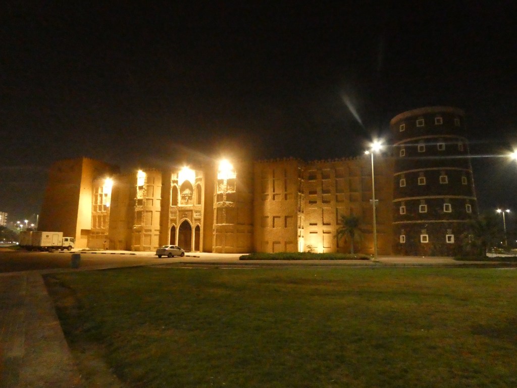 Vue nocturne d'un bâtiment historique en Arabie Saoudite, illuminé, avec une architecture traditionnelle.
