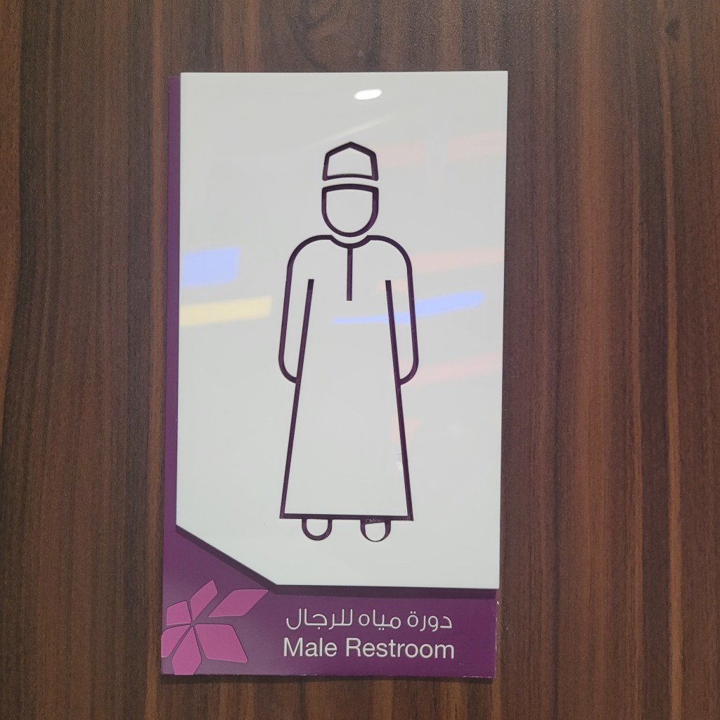 Panneau indiquant les toilettes pour hommes, représentant une figure masculine en tenue traditionnelle.