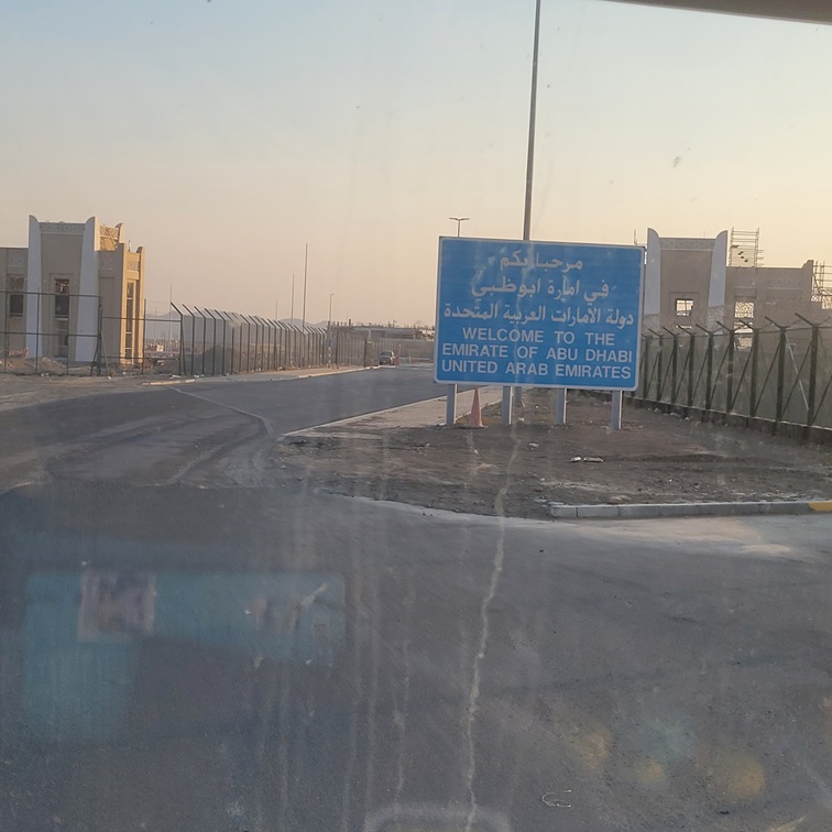 Panneau de bienvenue à l'Émirat d'Abou Dabi, Émirats Arabes Unis, avec des messages en arabe et en anglais.