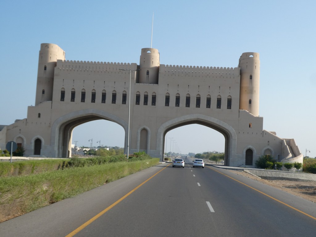 Une grande structure architecturale avec des arches, ressemblant à un château, située le long d'une route.
