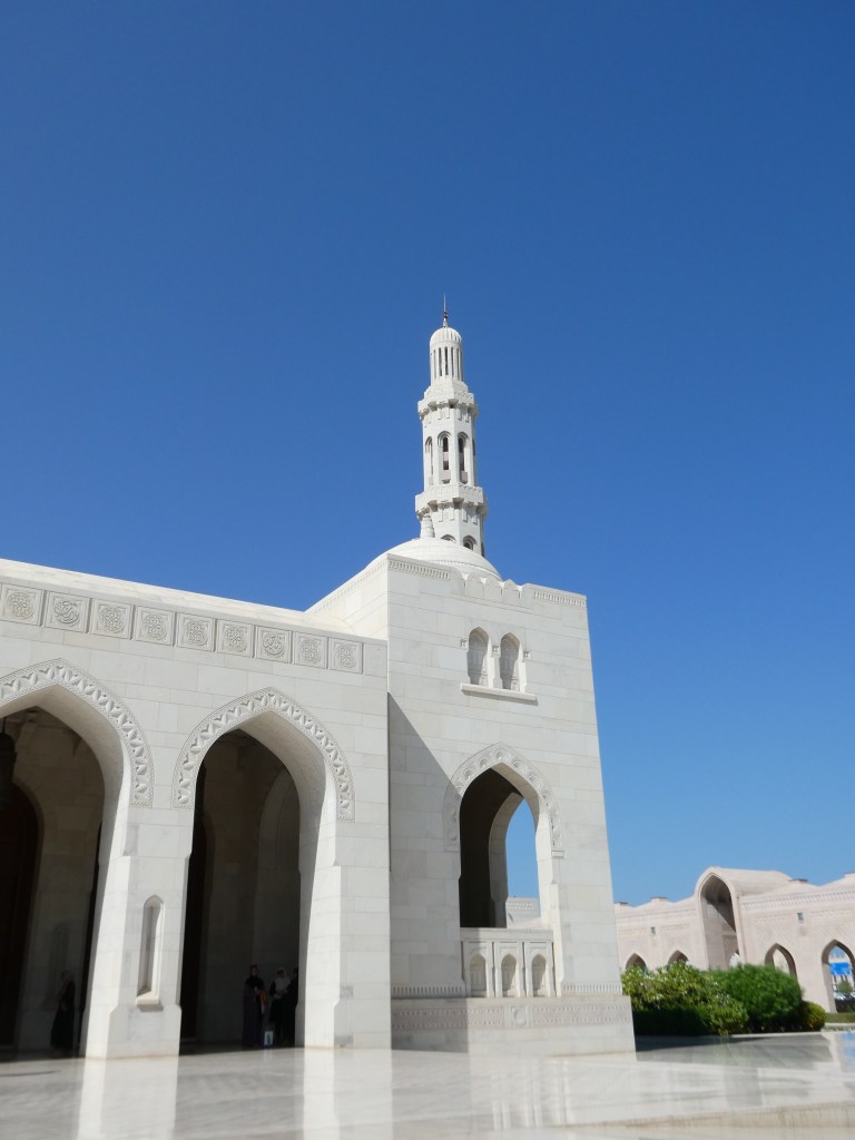 Vue d'un bâtiment architectural avec un minaret blanc sous un ciel bleu.